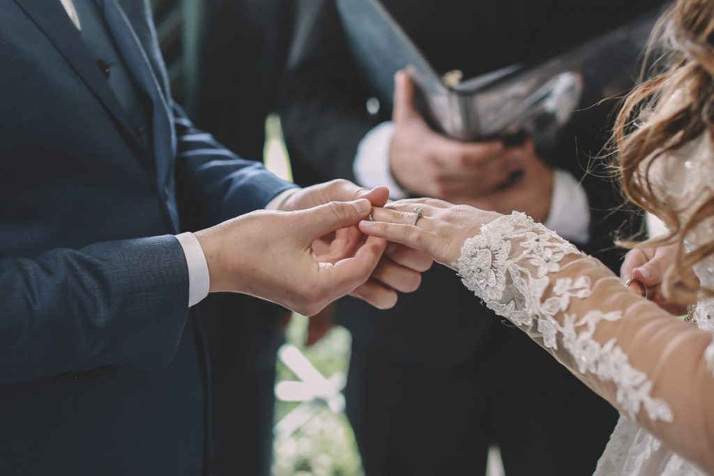 summer wedding central park ladies pavilion brazilian couple putting her ring on